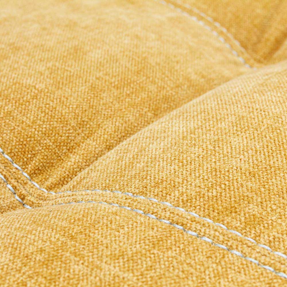 Close-up of yellow footstool fabric with visible stitching