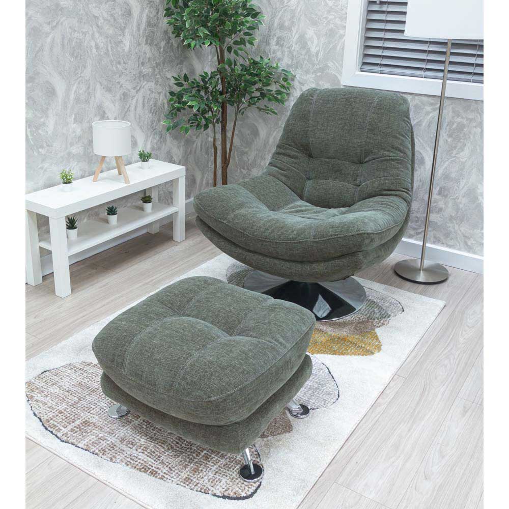 Sage Green occasional / accent chair with footstool in a room with a white wall and plant.