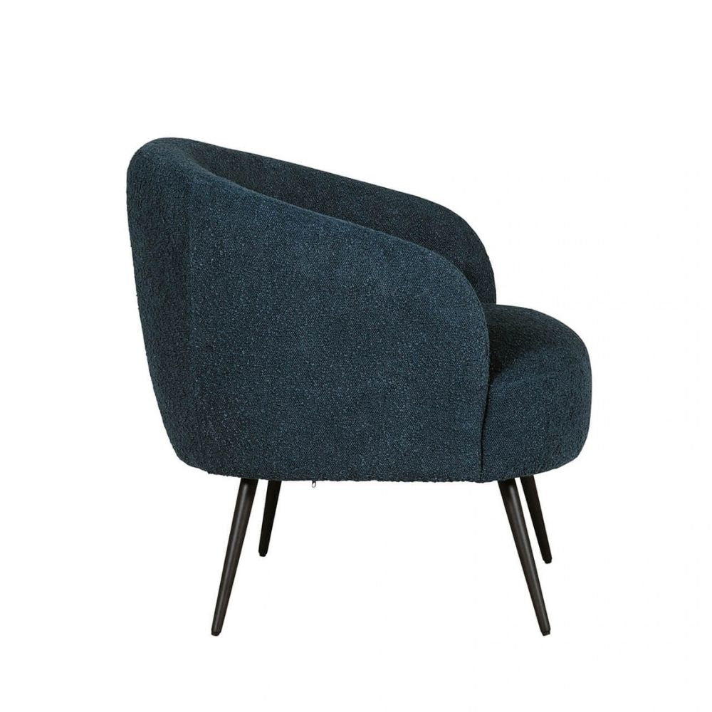 A modern barrel-style accent chair upholstered in a dark teal blue bouclé fabric, featuring tapered black metal legs, shown against a plain white background.