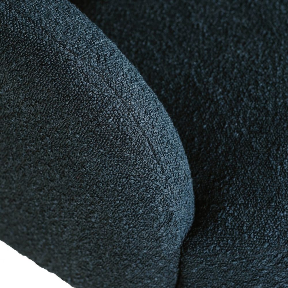 Close-up of a navy boucle fabric, showing the fine woven material and curved seam details.