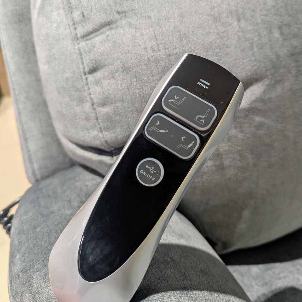 Control panel of a lift and rise recliner chair with buttons on a gray cushioned chair.
