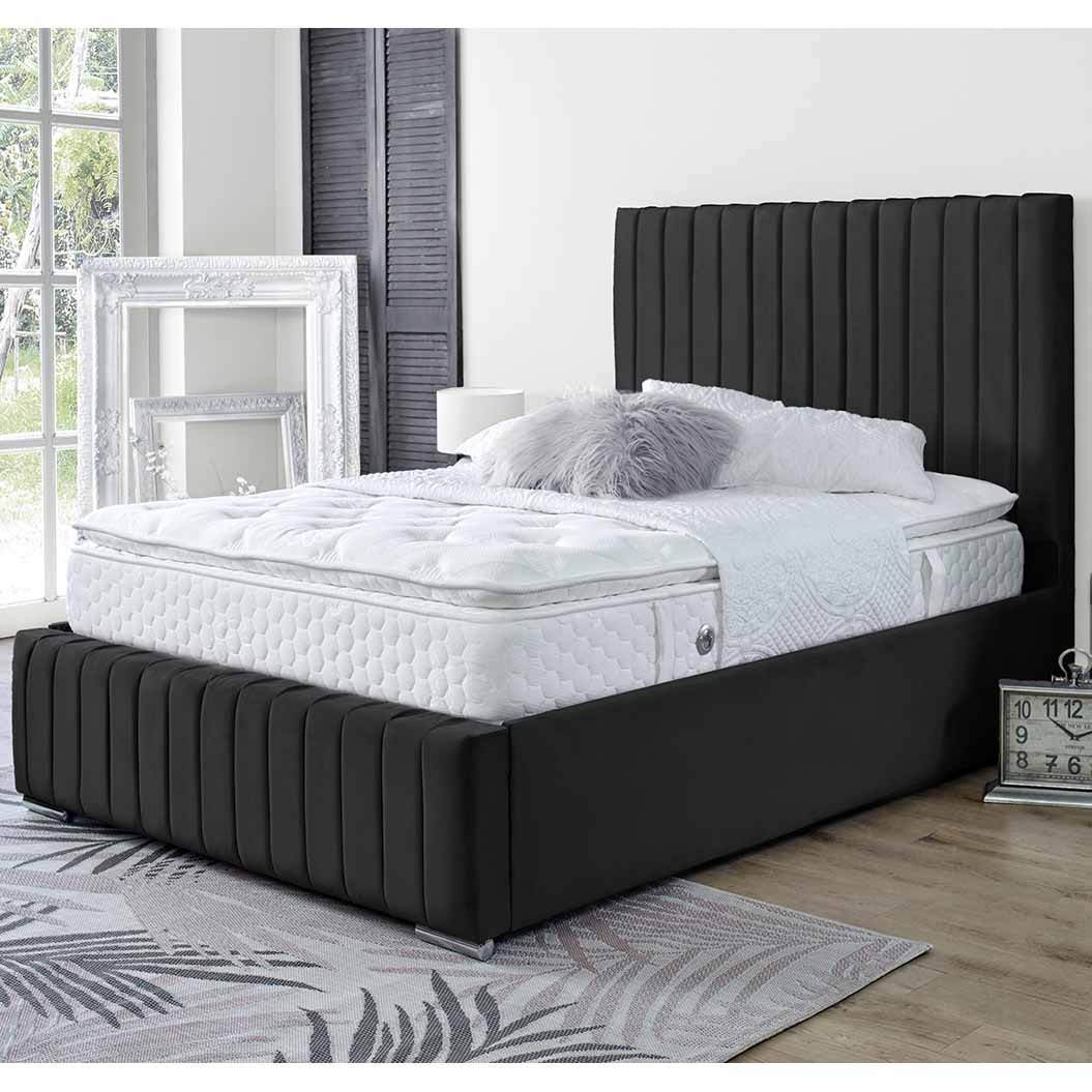 Black bed frame with white mattress in a room with large windows.
