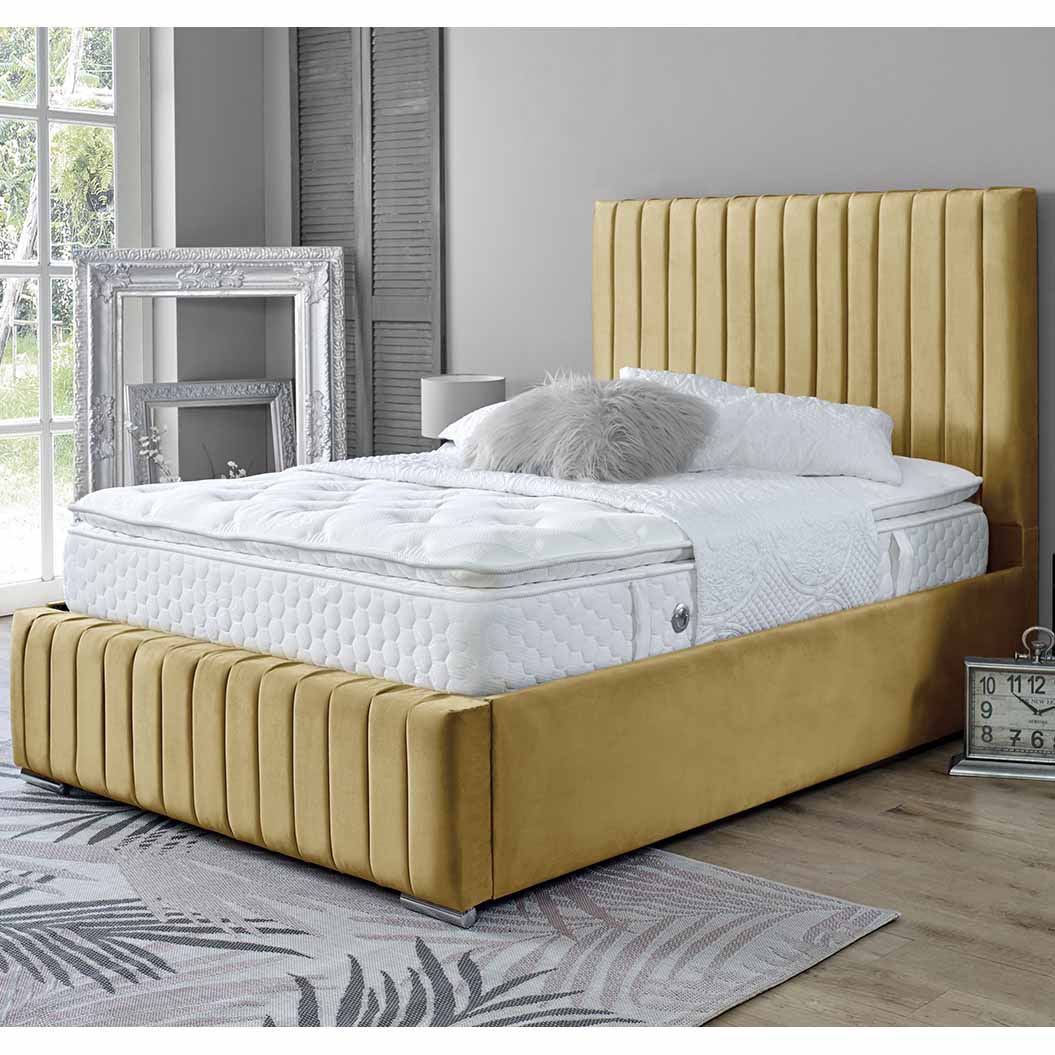 Mustard upholstered bed with white mattress in a room with large windows and decorative elements.