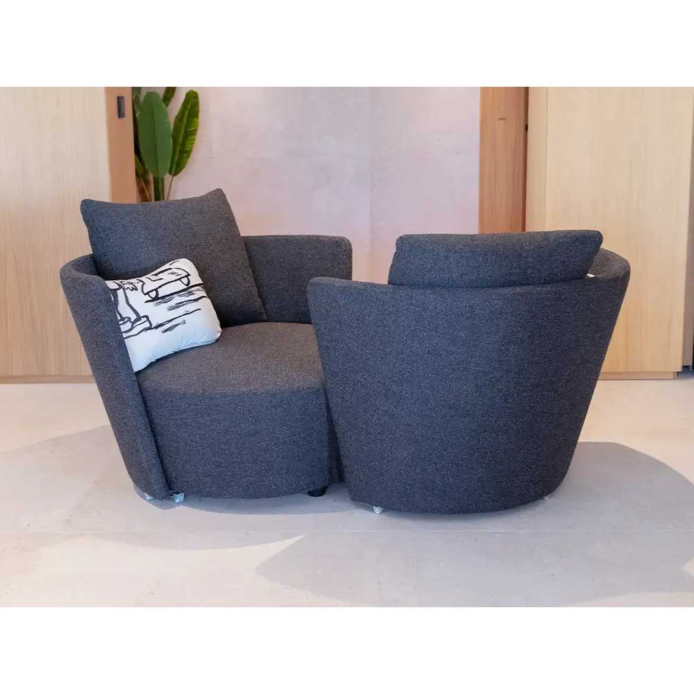 Gray infinity sofa with a pillow on a light-colored floor.