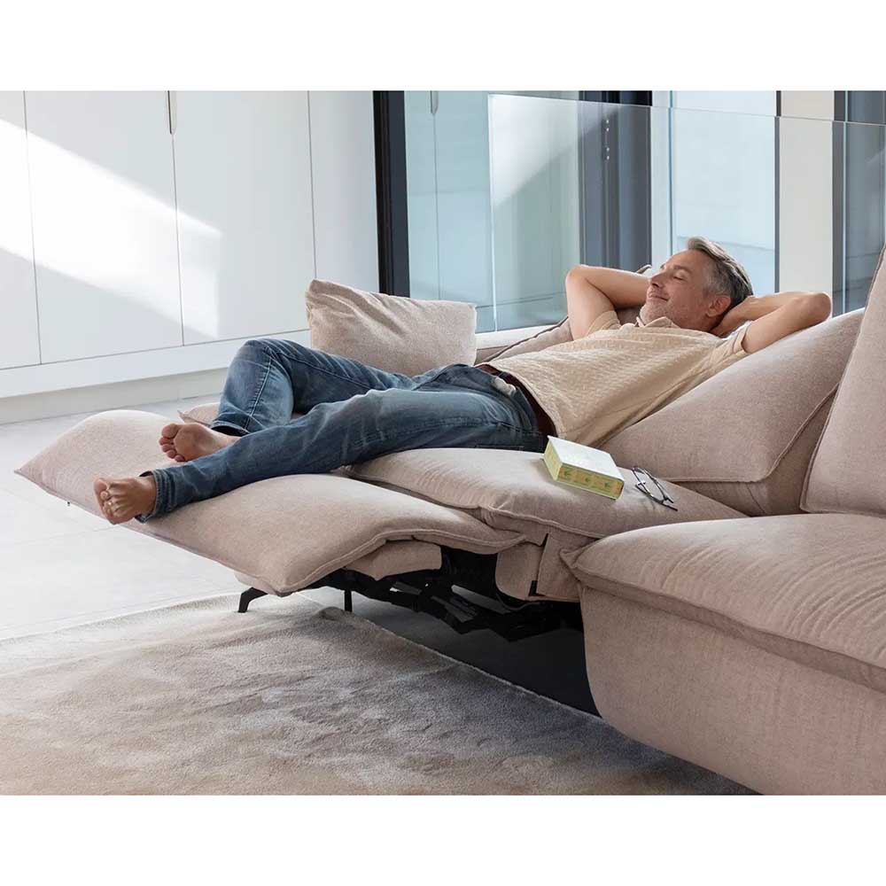 Man relaxing on a beige recliner in a modern living room.