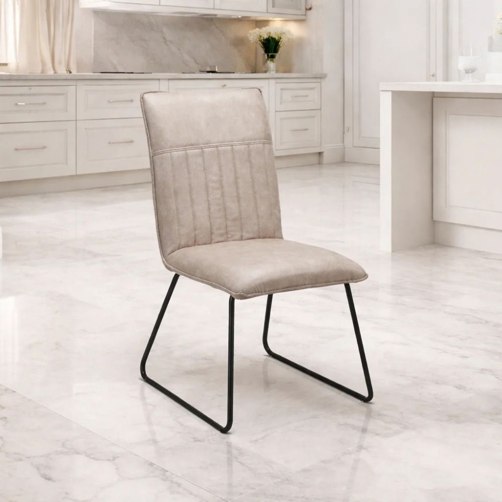 contemporary Alfie Dining Chair in Taupe padded upholstry with a black frame leg in a marble kitchen setting