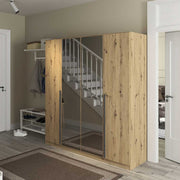 Wooden wardrobe with glass door in a room with staircase and shoes on the floor.