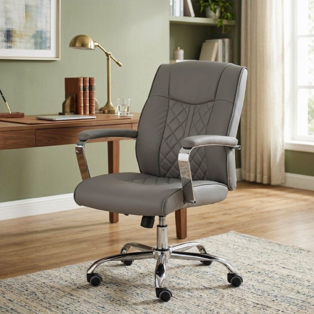 A gray faux leather office chair with diamond-quilted stitching on the backrest and seat, featuring chrome armrest supports and a five-star wheeled base, shown in a home office setting.