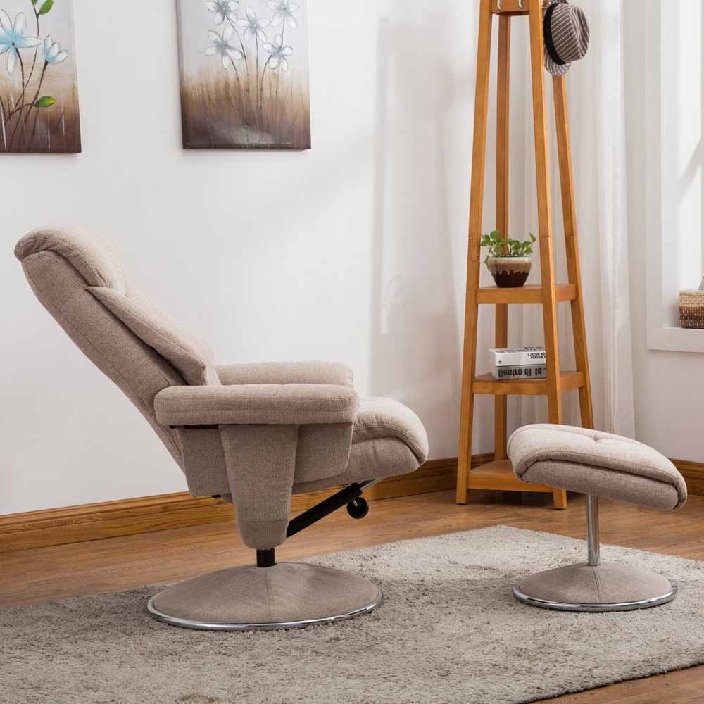 Beige recliner chair and footstool in a living room setting with a wooden shelf and decorative elements.