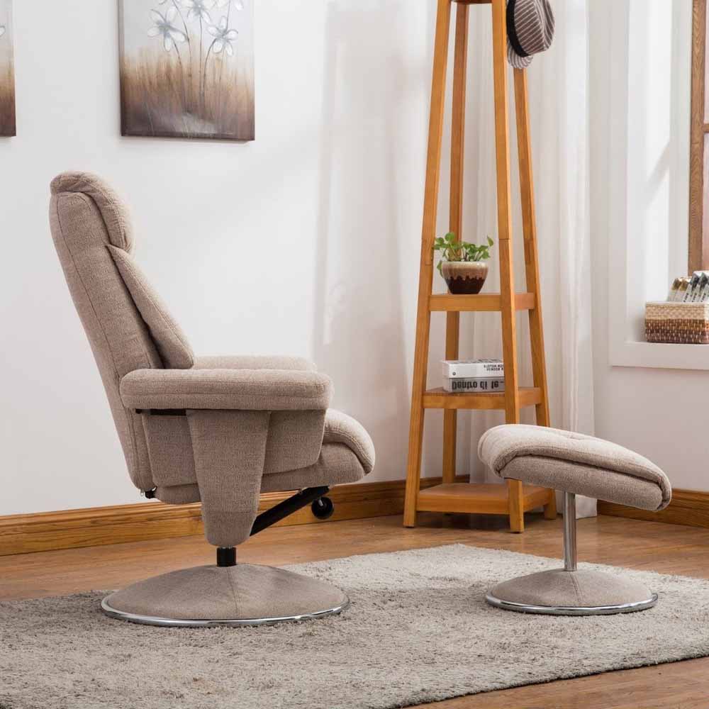 Beige recliner chair and footstool in a room with wooden floor and white walls.
