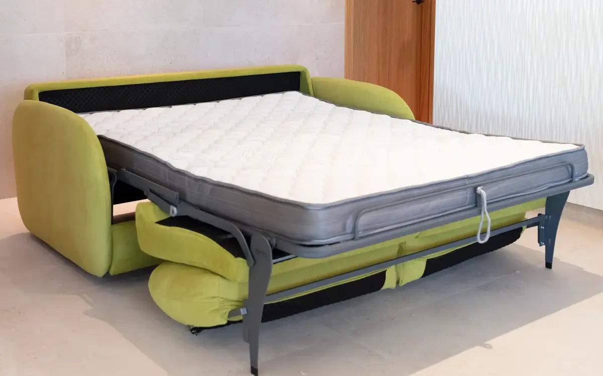 Green sofa bed with mattress pulled out in a room.