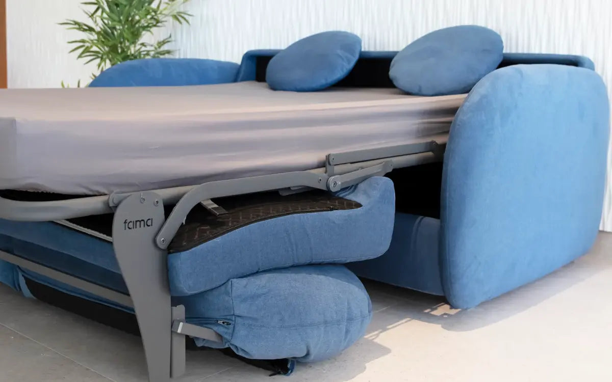 Blue sofa transforming into a bed with a visible brand logo.