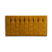 Mustard yellow tufted headboard on a white background
