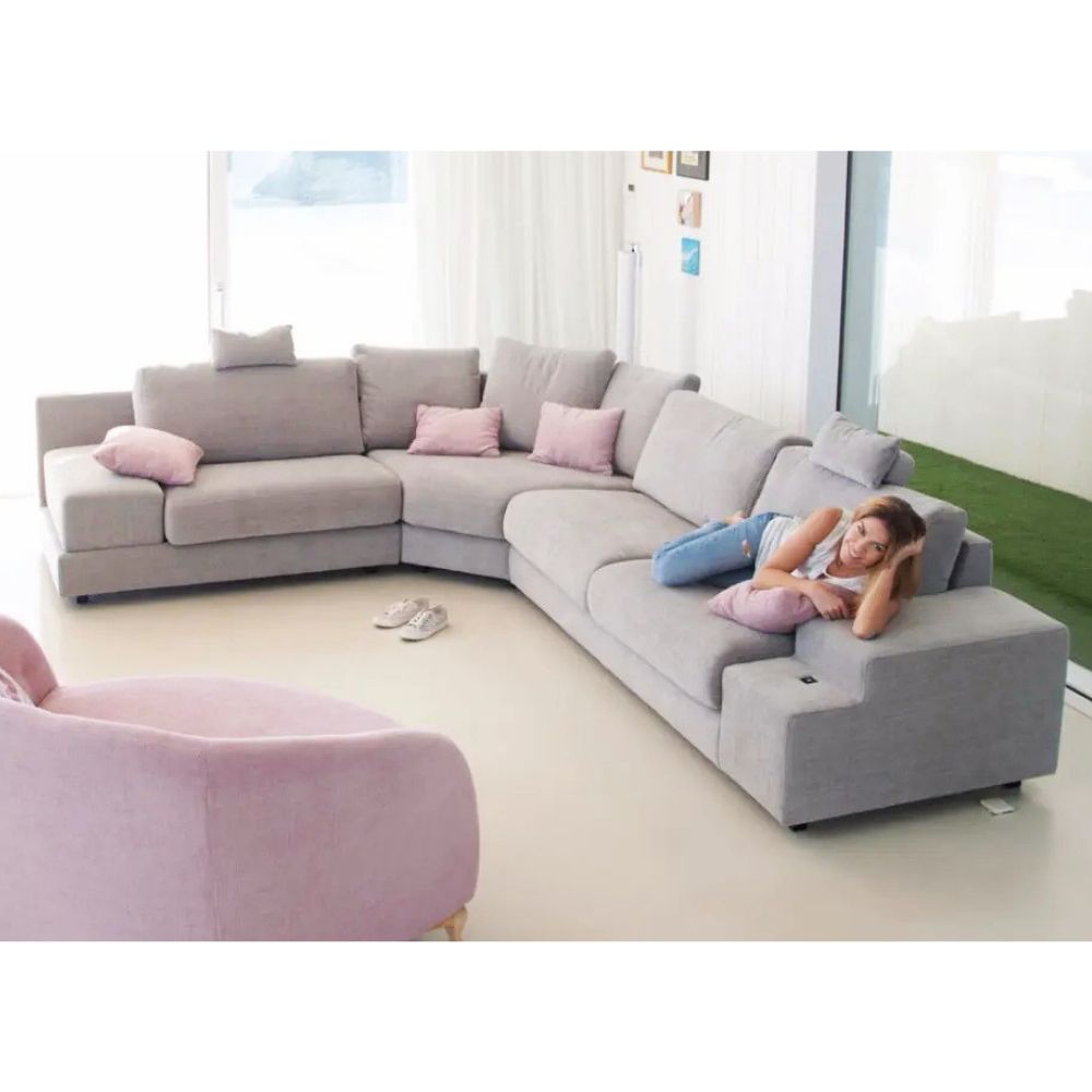 Gray modular sofa with pink cushions in a modern living room.