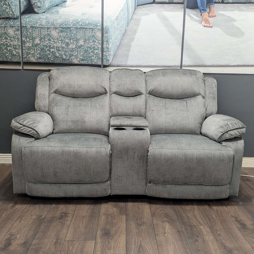 Silver - grey 2 seater electric reclining sofa with built in cup holders and wireless charging plate and storage compartment, shown in our furniture showroom in cork