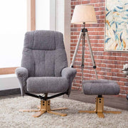 Gray recliner chair with footstool in a room with a lamp and wall art.
