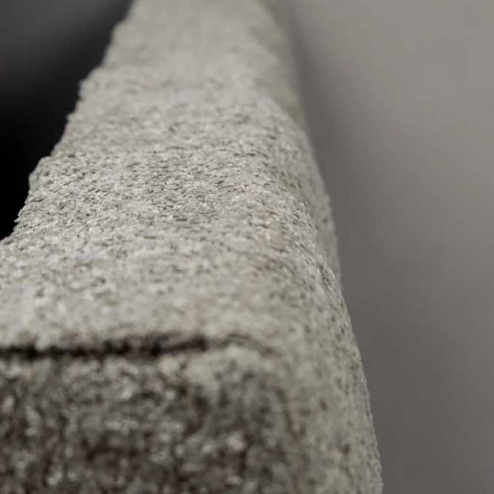 Close-up of a textured gray headboard with a blurred background