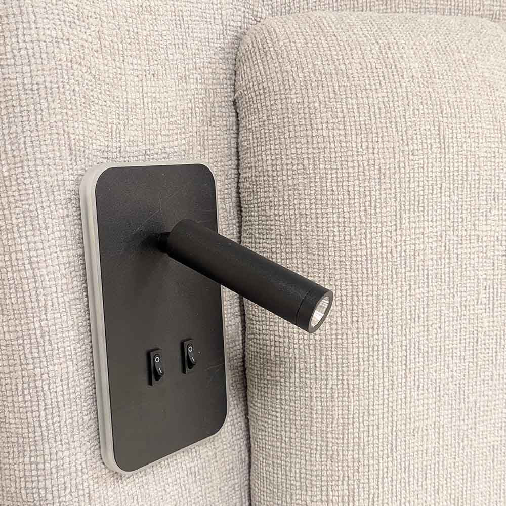 Black mounted light fixture on a textured grey headboard wall