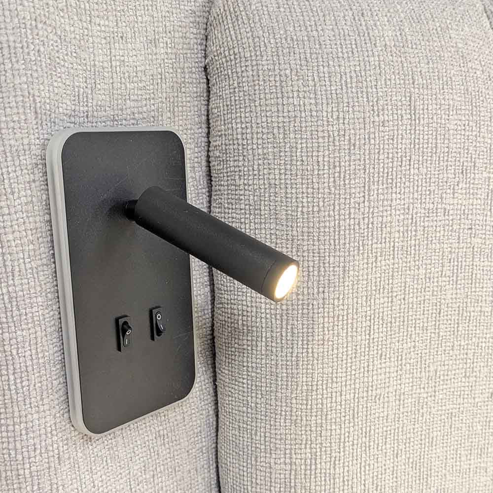 Modern wall-mounted LED light fixture on fabric headboard