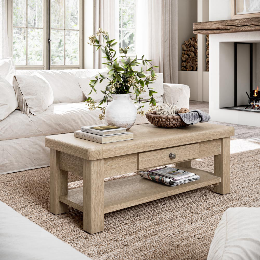 Light wood coffee table in a living room with a white sofa and decorative items.