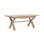 Wooden dining table with X-shaped legs on a white background