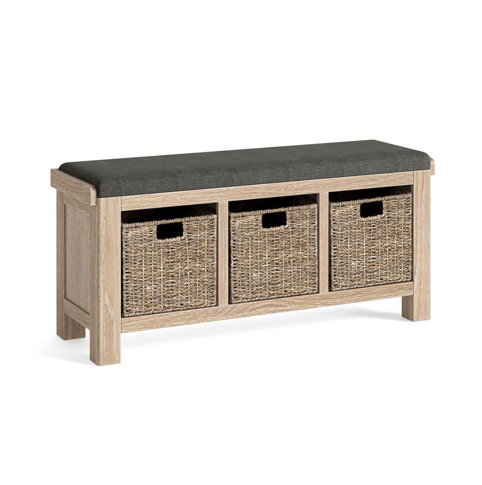Wooden bench with a charcoal grey cushion top and three wicker basket storage compartments on a white background.