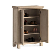 Wooden shoe cabinet with open doors displaying various shoes on a white background