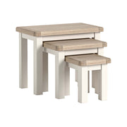 Set of three wooden nesting tables with a light finish on a white background