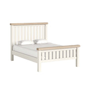 White and wood bed frame with white bedding on a white background