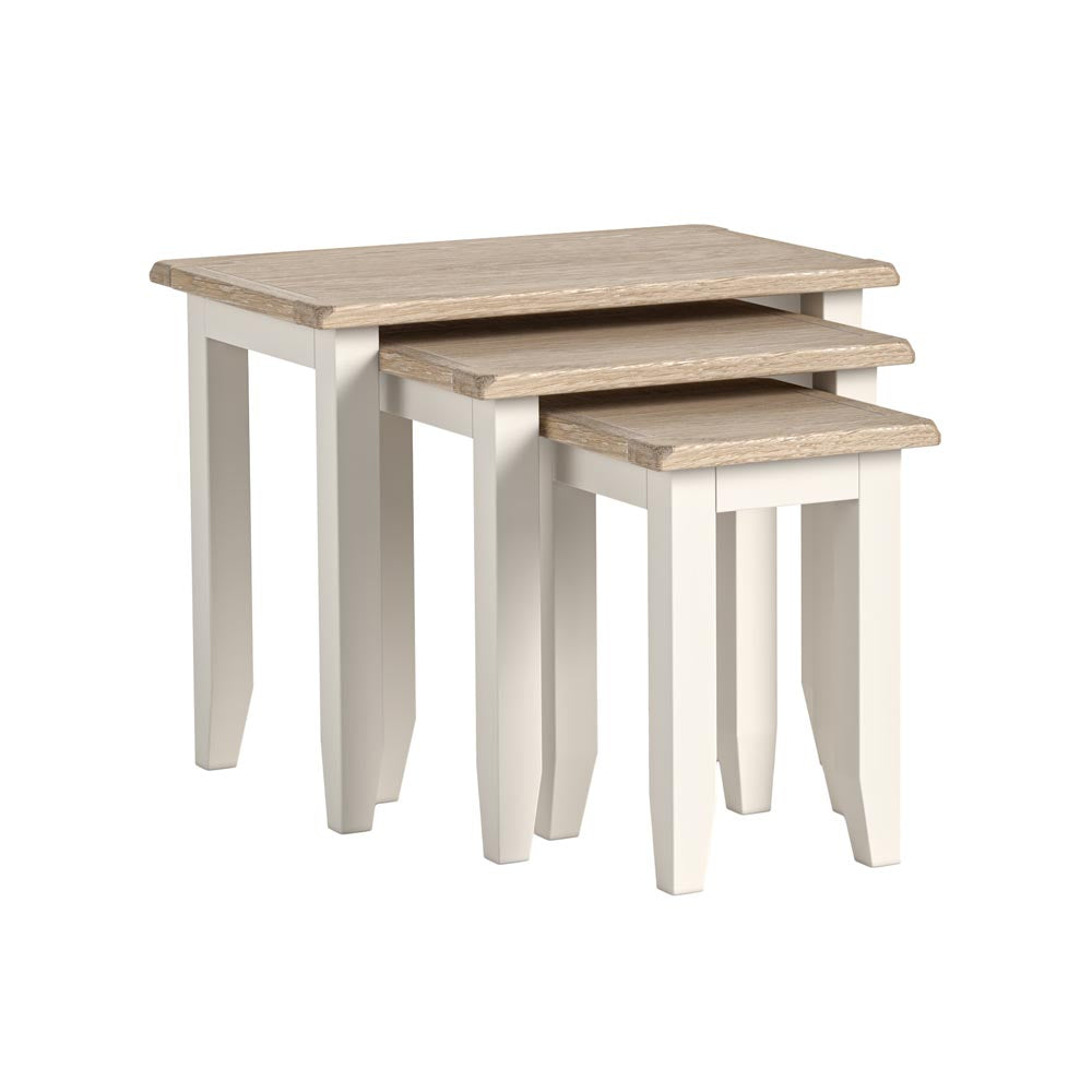 Set of three wooden nesting tables with light brown tops and white bases on a white background