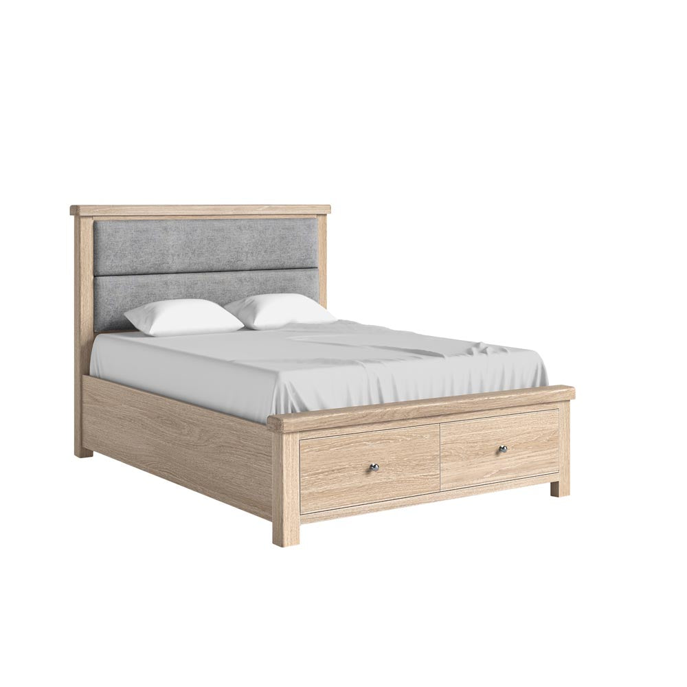 Wooden bed with gray upholstered headboard and white bedding on a white background