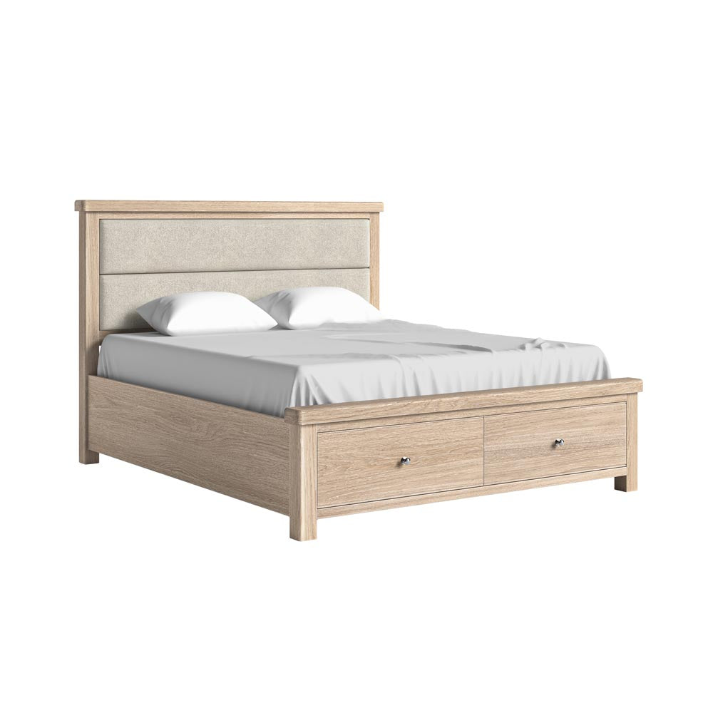 Wooden bed with storage drawers, cream fabric headboard and white bedding on a white background