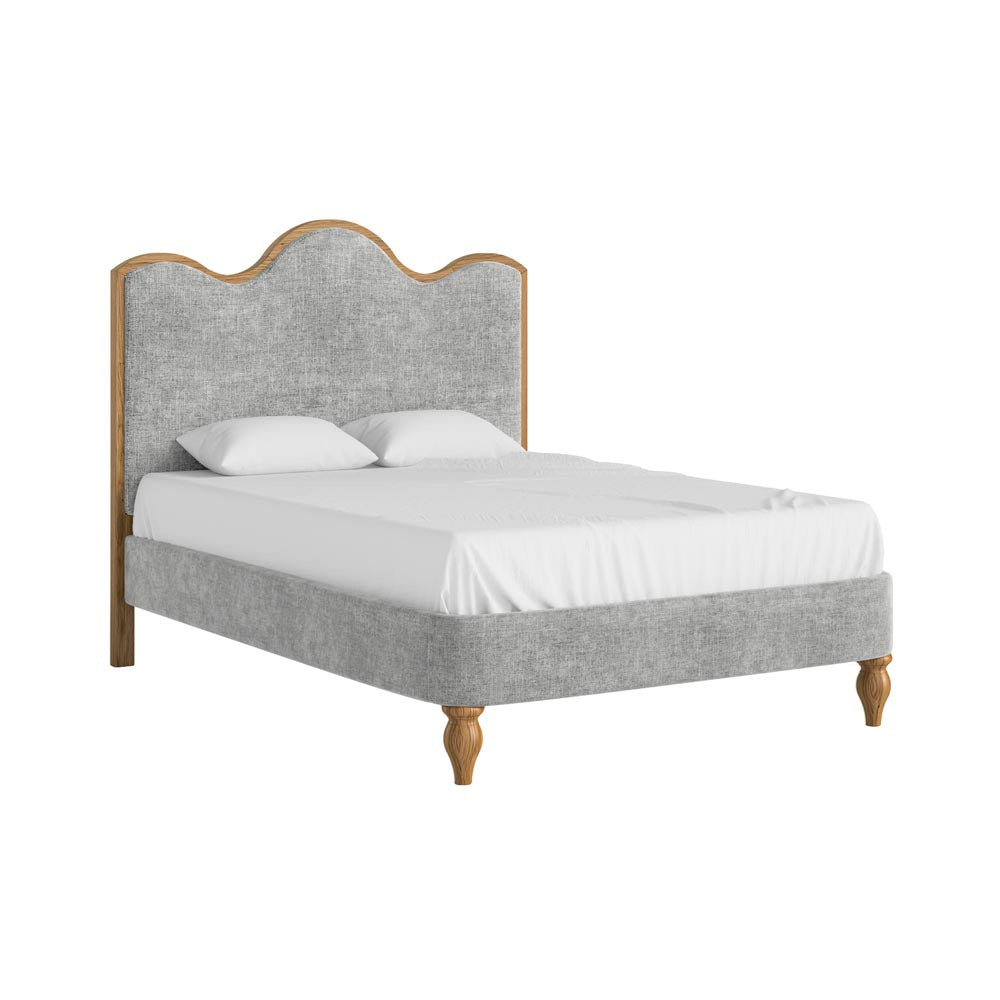 Bed with grey upholstered headboard and white bedding on a white background
