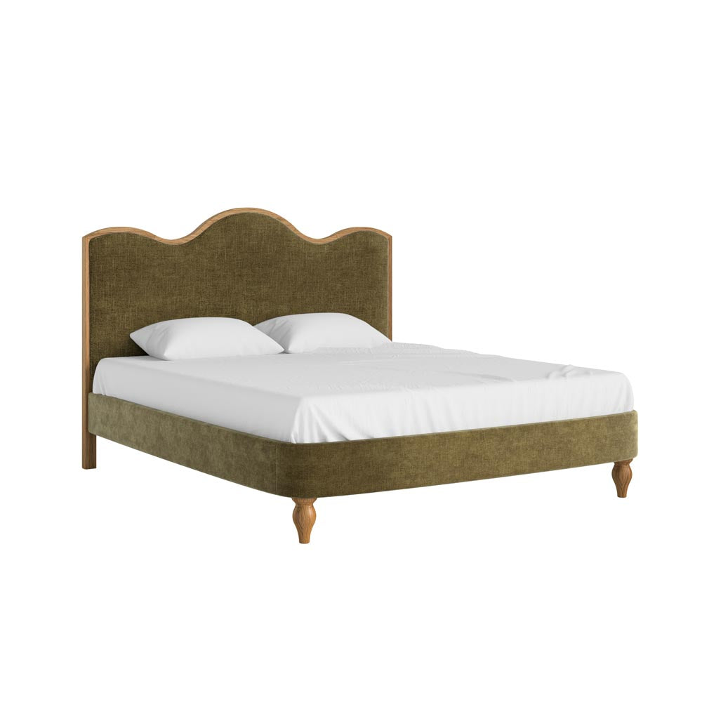 Bed with green upholstered headboard and white bedding on a white background