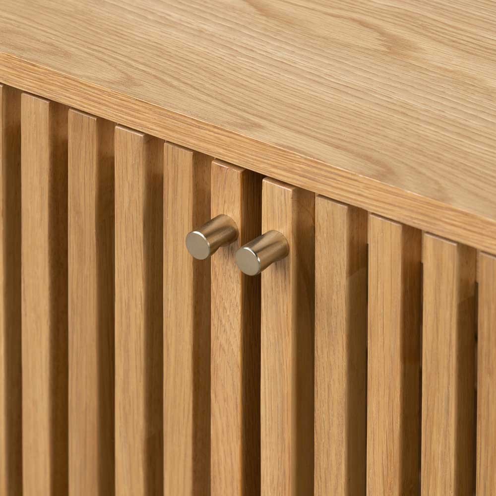 Close up of oak slatted design door with gold coloured handles. 