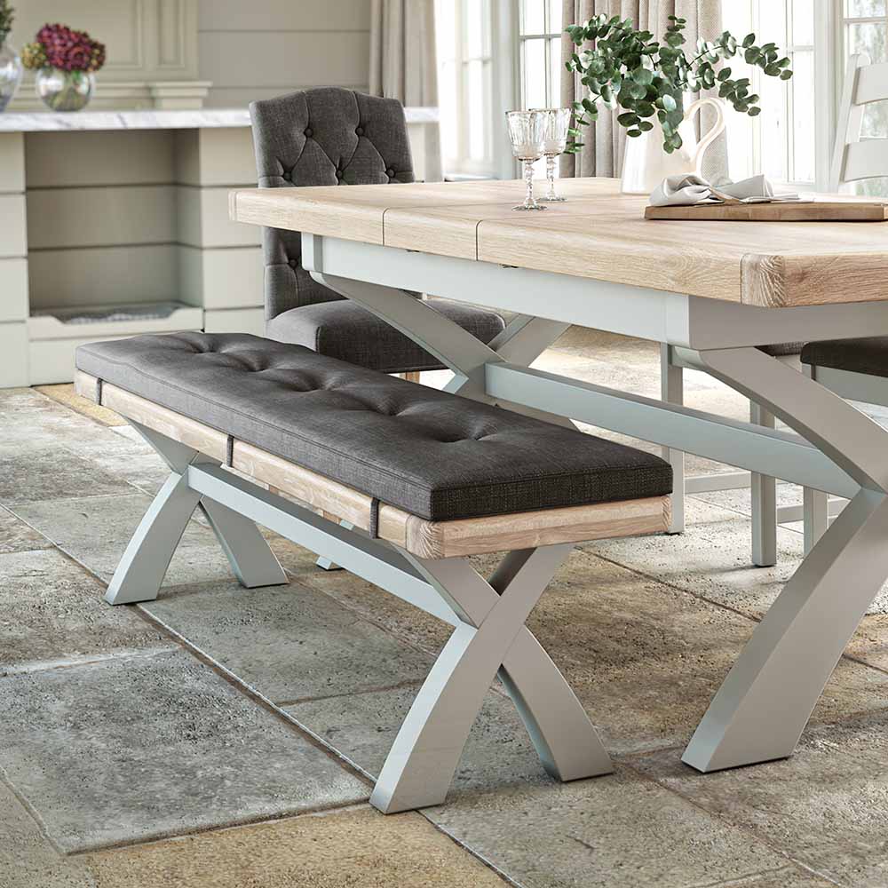 Long oak dining bench, painted grey with a charcoal grey coloured cushion. The bench is shown next to a matching table for reference / inspiration