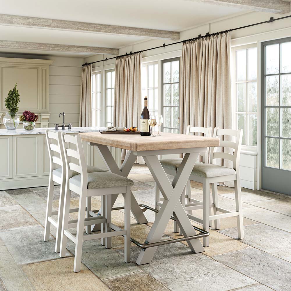 Grey painted oak Bar Table and 4 matching grey painted oak bar chairs set in a warm kitchen, with floor to ceiling glass doors and cream curtains.