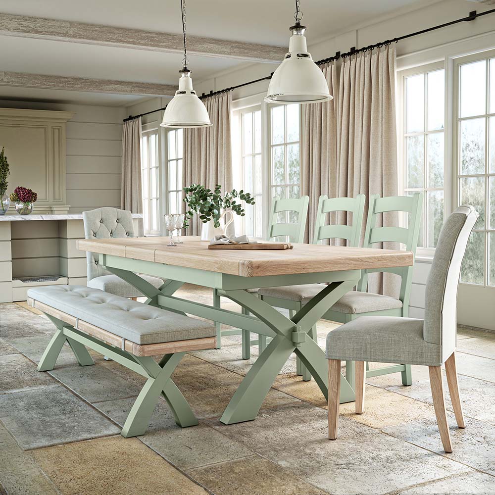 Dining room with a wooden table and chairs in a bright, naturally lit room.