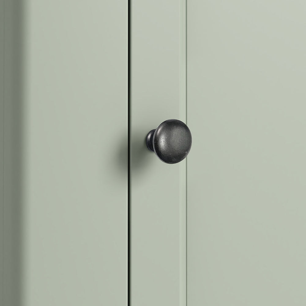 close up of sage green door with antique knob.