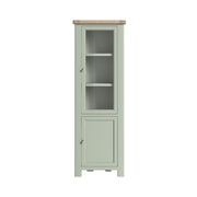 Oak display cabinet, with two doors, the top door has a glass panel, and 3 shelves are visible inside. the bottom door is solid oak and encloses a further 2 shelves. the whole unit is painted sage green, except for the unpainted oak top