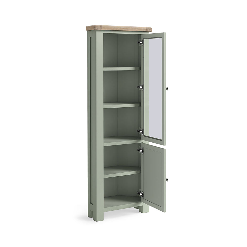 Oak display cabinet, with two doors, the top door has a glass panel, and 3 shelves are visible inside. the bottom door is solid oak and encloses a further 2 shelves. the whole unit is painted sage green, except for the unpainted oak top