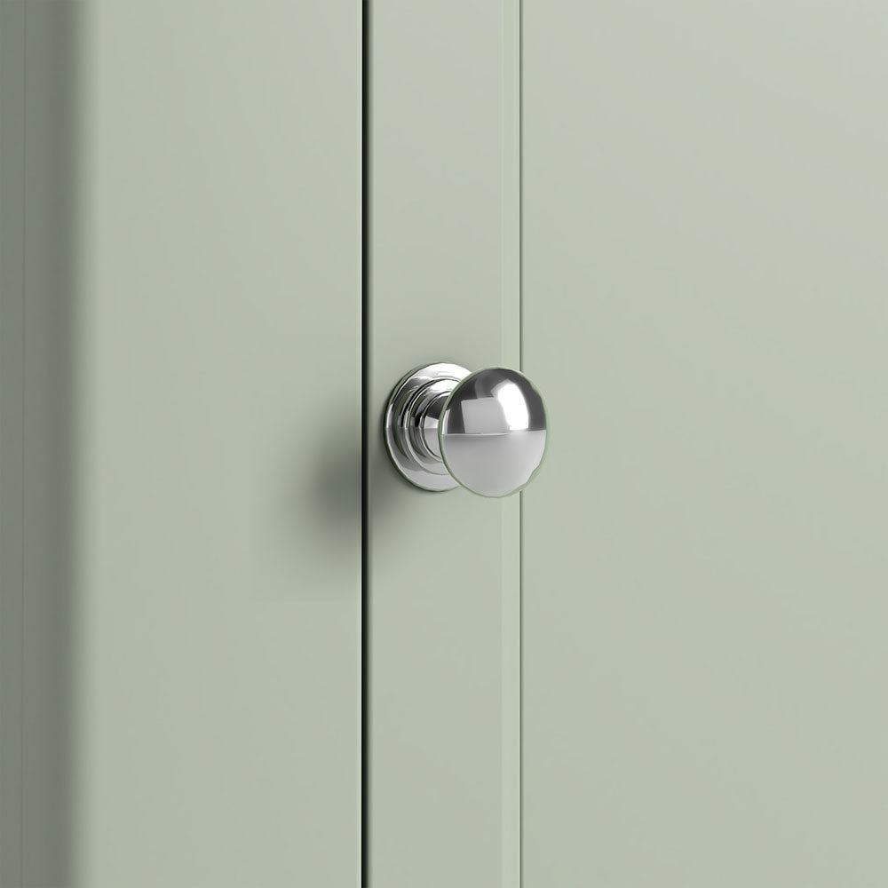Close up of sage green door with silver knob.