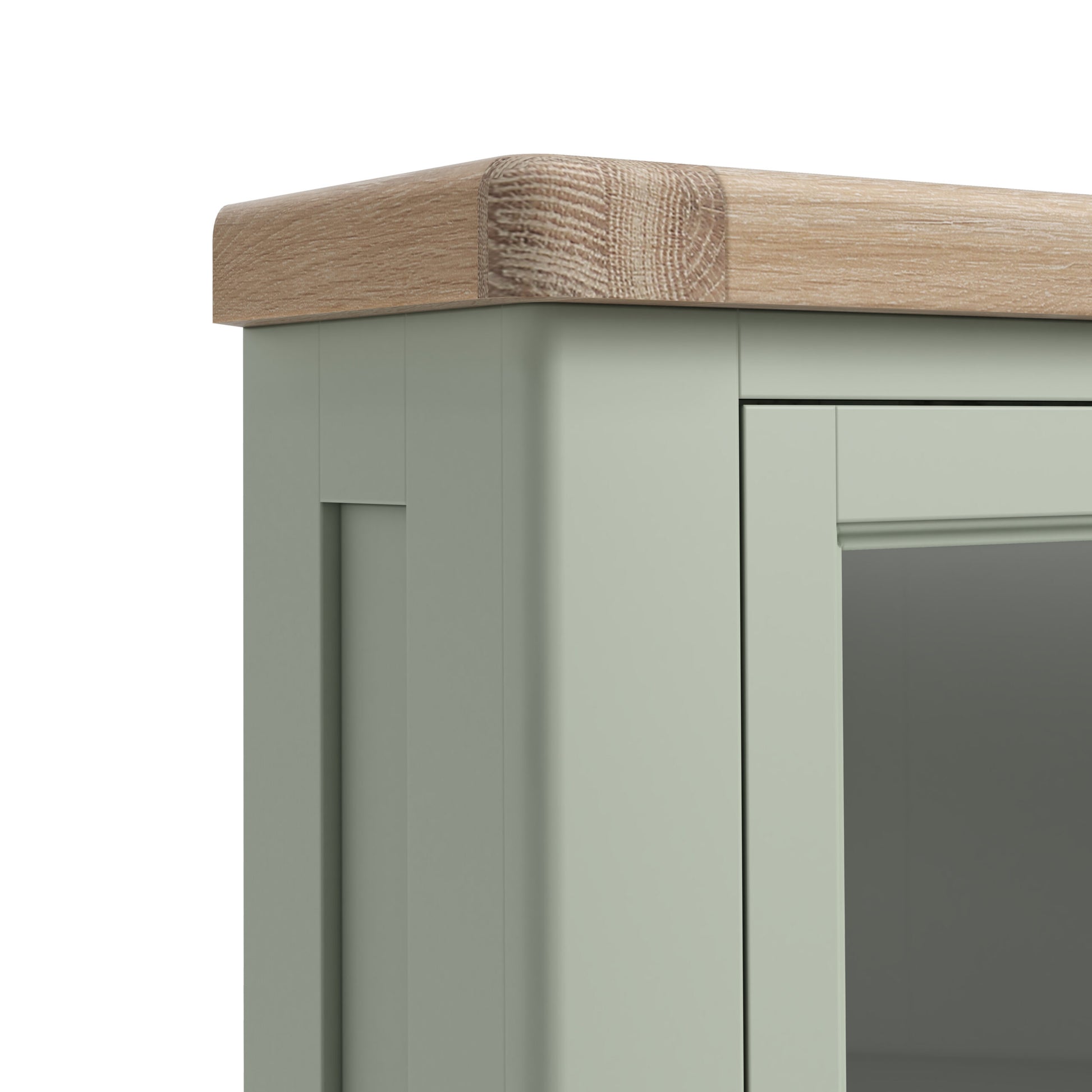close up of top left corner of sage green painted oak display cabinet, highlighting the unpainted thick feature oak top and glass door.