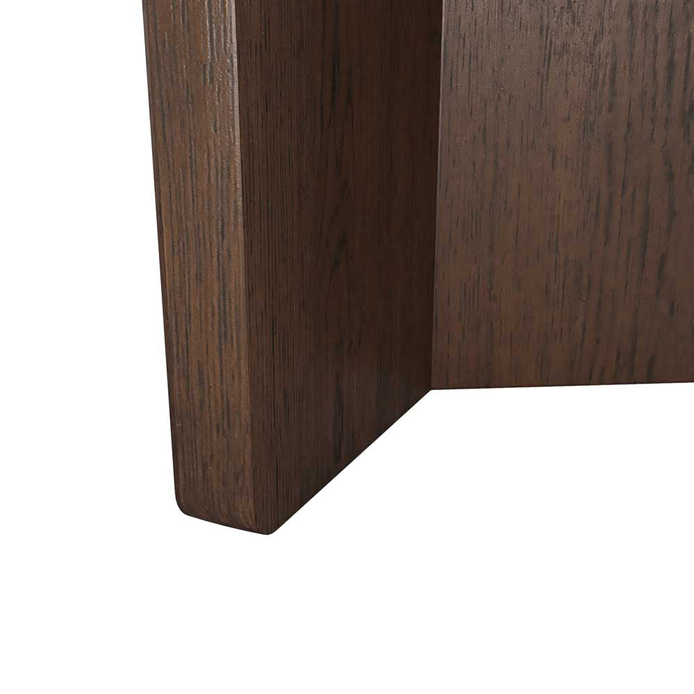 Close-up of a dark brown wooden furniture corner showing the wood grain texture and beveled edge on a white background.