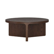 A round dark brown wooden coffee table with a unique pedestal base and single front leg, shown against a plain white background.