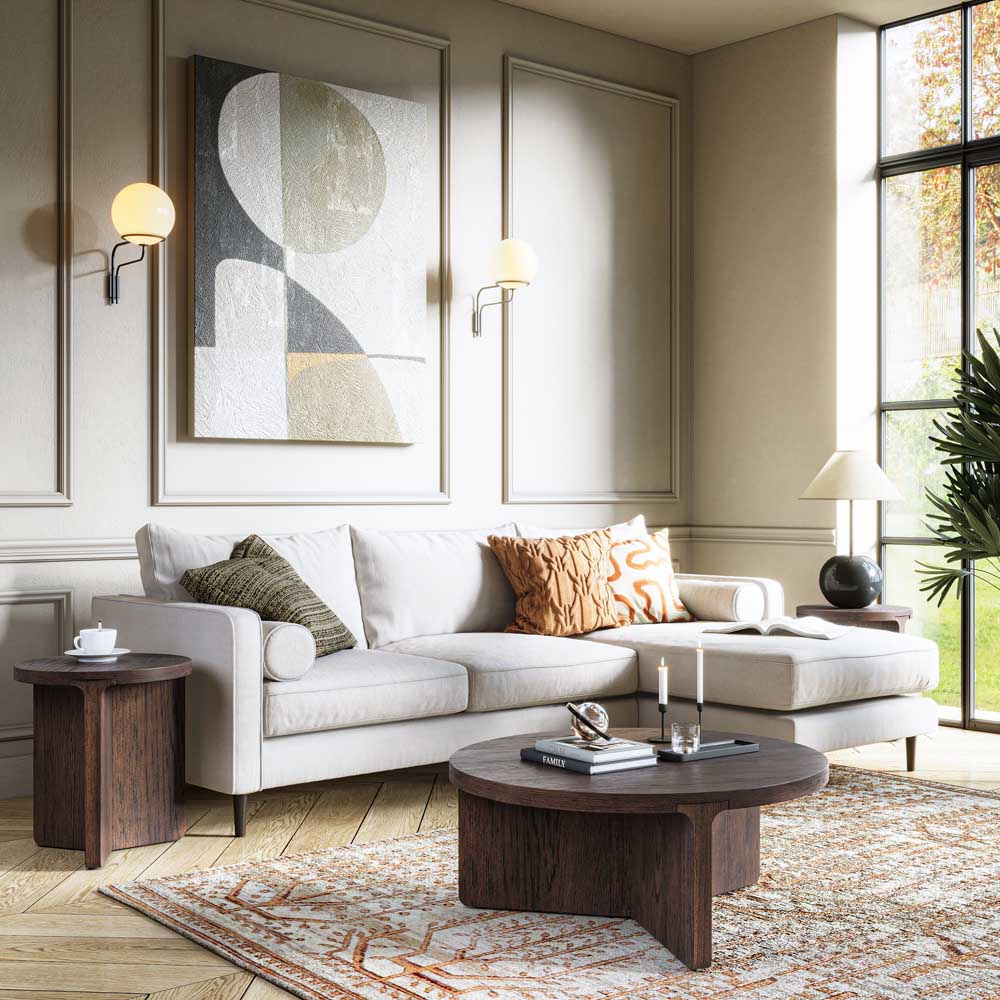 A modern living room featuring a light beige sectional sofa with decorative throw pillows, a dark wood coffee table, a patterned area rug, and a large abstract art print on the wall.