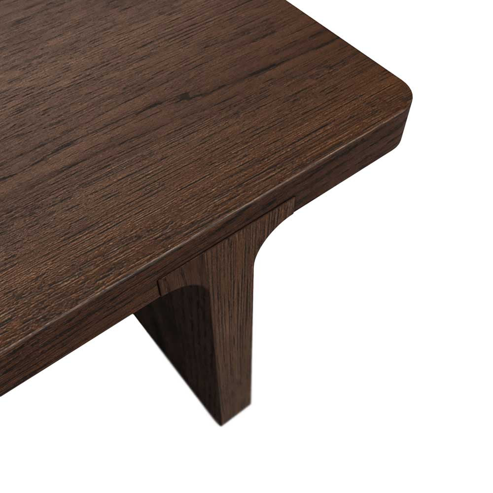 Close-up of a dark brown wooden table corner showing the wood grain texture and a single leg against a white background.