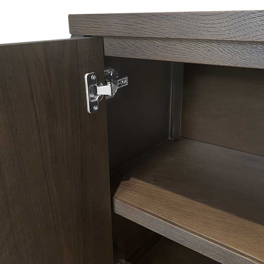 Close-up of a dark brown wood cabinet door with a silver metal hinge attached to the side, showing the cabinet interior and shelf.