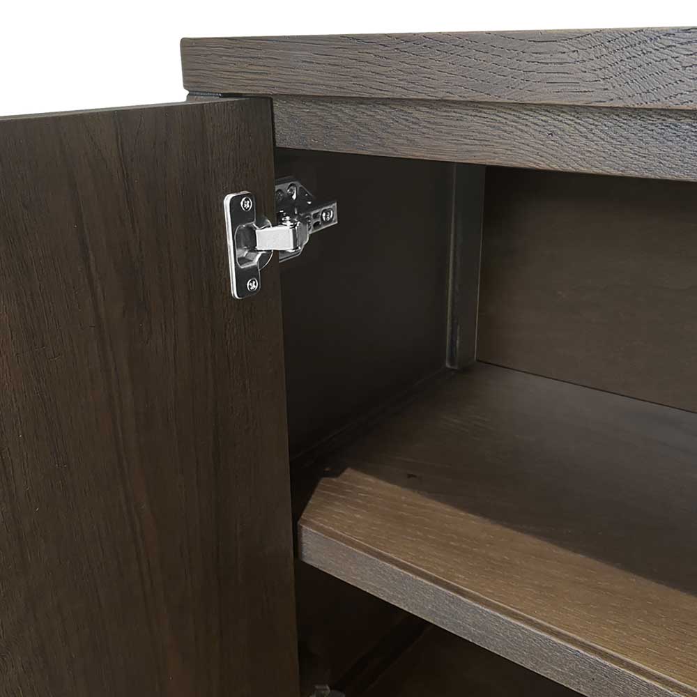 Close-up of a dark brown wood cabinet door with a silver metal hinge attached to the side, showing the cabinet interior and shelf.