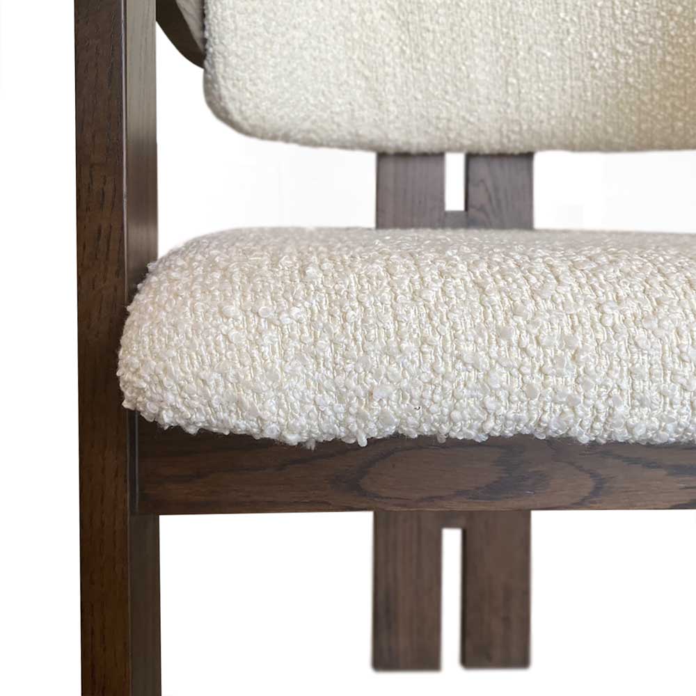 Wooden chair with white cushioned seat and backrest on a white background